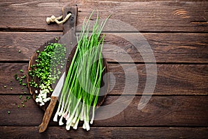 Green onion or scallion on wooden board, fresh spring chives