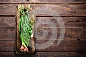 Green onion or scallion on wooden board, fresh spring chives