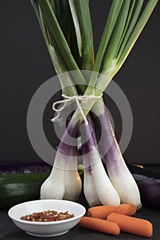 Green Onions and Carrots bunched on a slate cutting board with a
