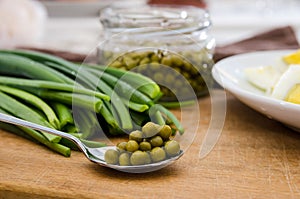 Green onions, chopped eggs on a plate and canned peas on a wooden board. The concept of cooking spring salad.