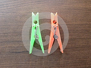 2 green and orange plastic spring Clothespins