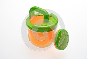 Green and orange plastic watering can isolated cutout on white background. Overhead view