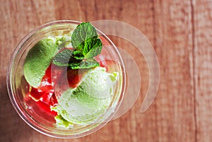Green Organic Avocado Ice Cream and Strawberry Sorbet with red wine in a plastic cup with mint