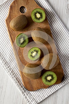 Green Organic Kiwi Fruit on a rustic wooden board, top view.