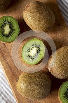 Green Organic Kiwi Fruit on a rustic wooden board, top view. Flat lay, overhead, from above. Close-up