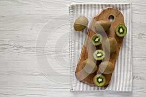 Green Organic Kiwi Fruit on a rustic wooden board, top view. Flat lay, overhead, from above. Copy space