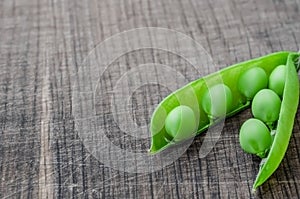 Green organic peas on wooden background