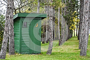 Green Outhouse in Pine Forest