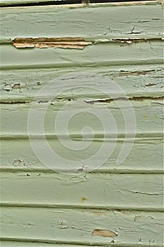 Green paint peeling timber weatherboard wall