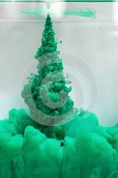 Green paint splash cloud in the water, abstract background