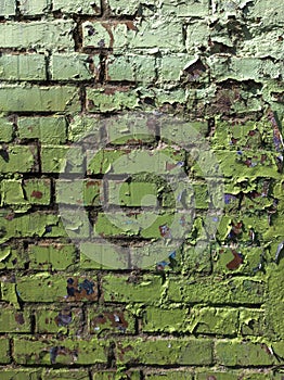 green paint stripping off from an old brick wall photo