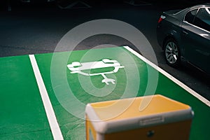 green painted indoor parking lot with charging port for battery electric vehicles at car park.