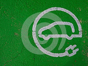 GREEN PAINTED SIGN ON THE GROUND FOR ELECTRIC VEHICLE RECHARGING