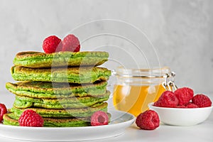 Green pancakes with matcha tea, raspberries and honey. healthy breakfast dessert