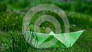 Green paper boat outdoor in grass