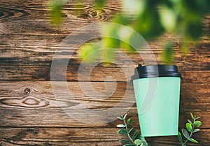 Green paper eco cup on wooden table