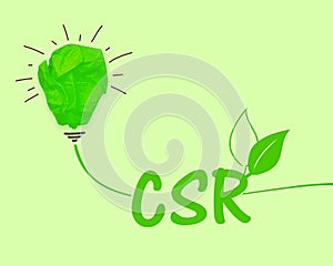 Green paper light bulb with acronym CSR Corporate Social Responsibility on green background