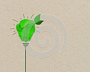 Green paper light bulb metaphor for recycling and green renewable energy green climate concept on brown recycled paper