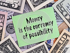 A Green paper note with phrase Money is the Currency of Possibility on a dollar bills background