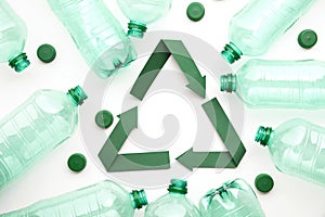 Green paper recycling symbol with empty plastic water bottles