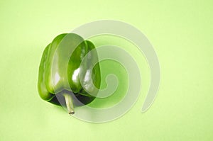 Green paprika close-up/Green paprika pepper over green background, top view and copy space