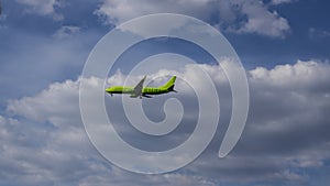 Green passenger air plane in the cloud sky