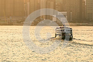 Green passenger Ferry in victoria harbour with cityscape background against morining sunrise, services between Kowloon and Hong