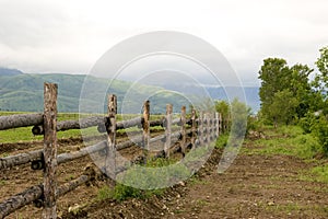 Green pasture and fence at mountains