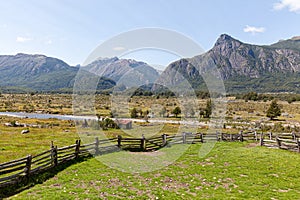 Green pasture, wood fence and mountains of Chilean Patagonia in the background photo