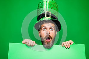 Green patricks background. Man in Saint Patrick`s Day leprechaun party hat having fun on green background. Copy space. photo