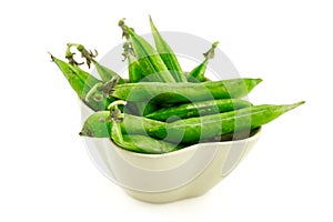 Green pea pods long fresh tasty vegetables ceramic bowl on an isolated background