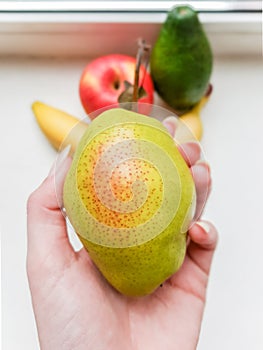 Green pear in hand