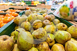 Green pears harvest. Fresh pears in a basket on shelf in supermarket close up