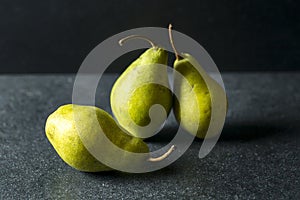 Green pears lying on dark background
