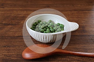 Green peas in a bowl on a wooden table