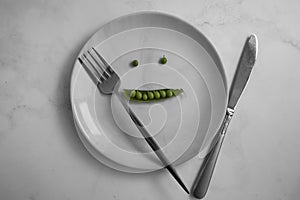 Green peas on an empty plate