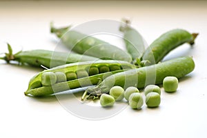 Green peas, fresh in the tricks, on a white background