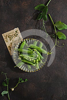 green peas in pods on a dark background
