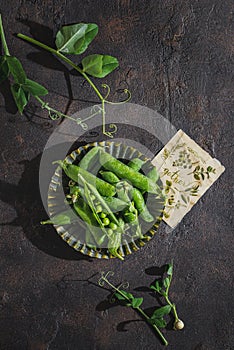 green peas in pods on a dark background