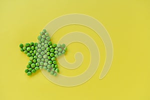 Green peas in the shape of a star on a yellow background
