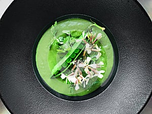 Green peas soup with roquette flowers