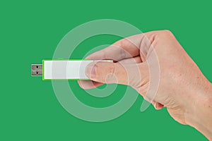 Green pen drive on hand with isolated green background