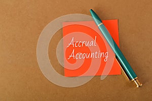 Green pen and orange paper written with ACCRUAL ACCOUNTING