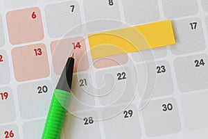 Green pen points to a fourteen number of calendar and have blank