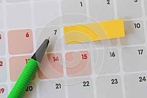 Green pen points to a seven number of calendar and have blank ye