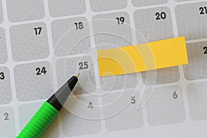 Green pen points to a twenty-five number of calendar and have bl