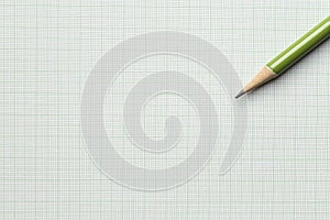 Green pencil on graph paper background