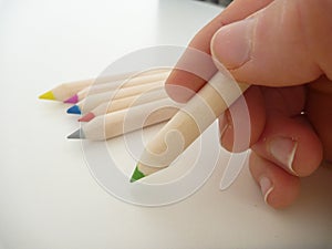 Green pencil in a hand writing