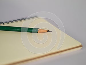 Green pencil on a notebook