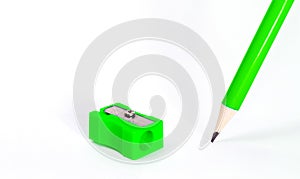 Green pencil with green pencil sharpener on white background. Stationery. Office tool. Back to school. Space for text. Education.